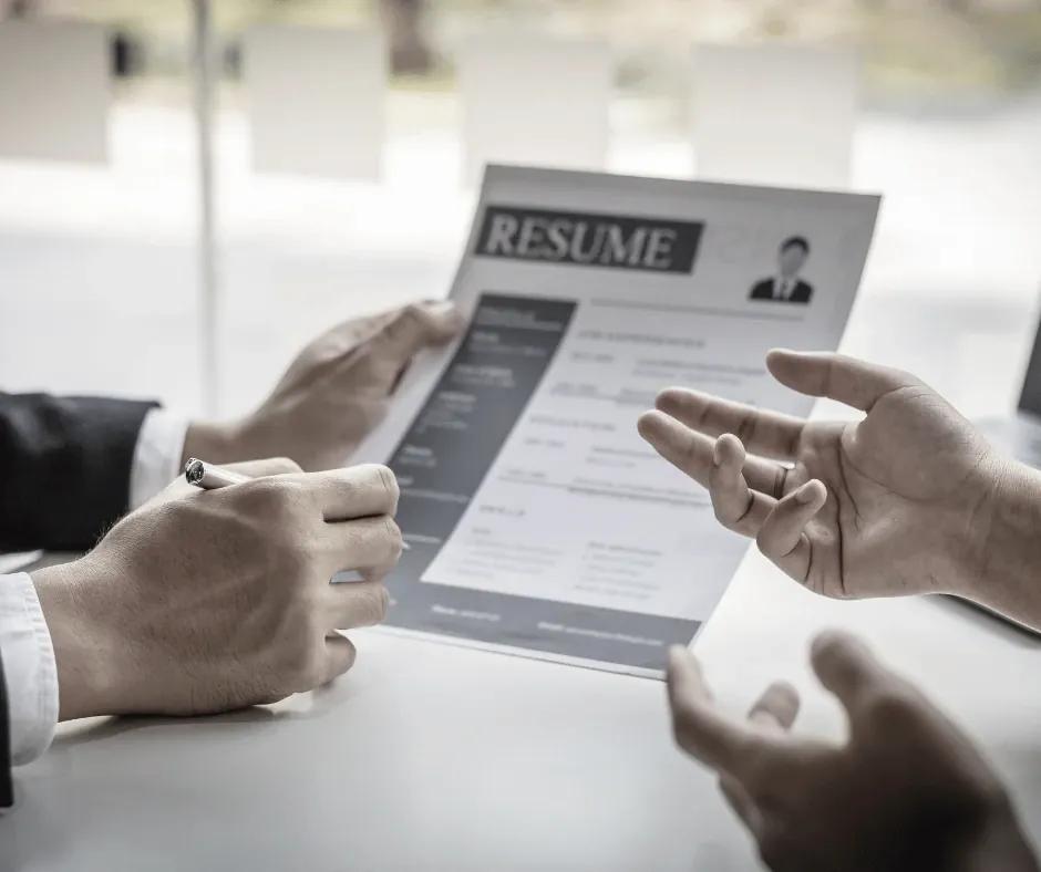 Candidate highlighting sections on a printed resume during a review.